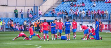 Atletico de Madrid players warming up before the game clipart