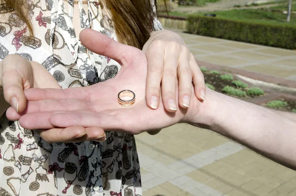 Мужская рука с обручальным кольцом в женских руках — стоковое фото