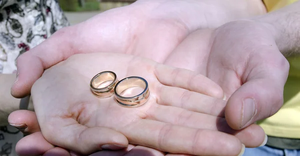 Homens de mãos dadas com anéis de casamento de mão de uma mulher — Fotografia de Stock