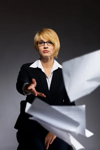 Beautiful young business woman dropping heap of paper — Stock Photo, Image