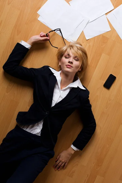 Schöne blonde junge Geschäftsfrau auf dem Boden liegend — Stockfoto