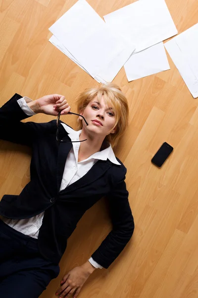Krásná blondýna mladá podnikatelka leží na podlaze — Stock fotografie