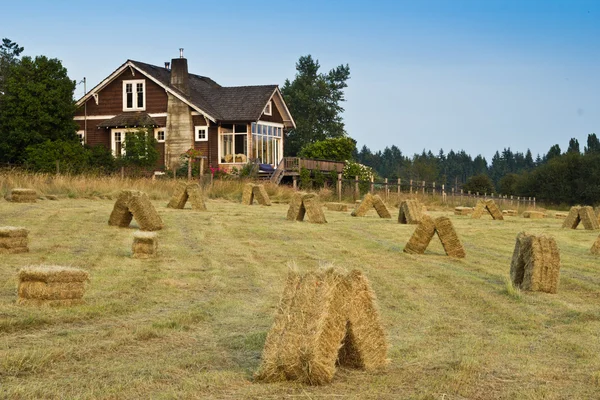 Old Farmhouse with Hay Field Stock Photo