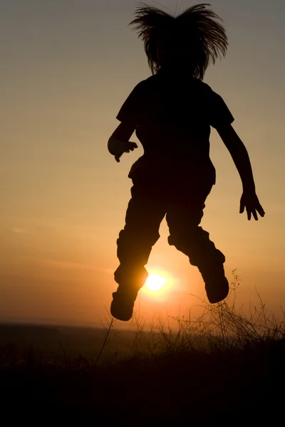 Jump of little girl - silhouette in sunset — Stock Photo, Image