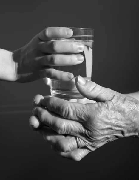 祖母と水のガラスと孫の手 — ストック写真