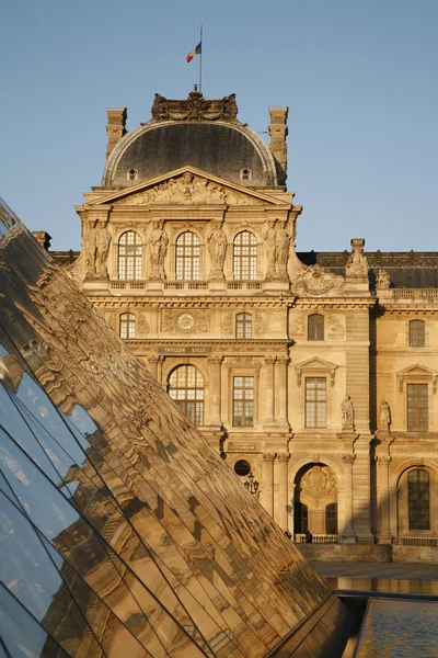 PARÍS, FRANCIA - 16 de junio: La gran pirámide en el Louvre y fachada de Pavillon Sully a la luz del atardecer el 16 de junio de 2011 en París. Pavillon Sully fue construido entre 1624 y 1654 bajo el rey Luis XIV . — Foto de Stock