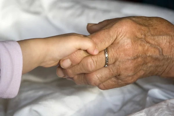 Рука старухи и ребенка - помощь — стоковое фото