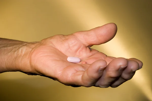 Pill on the hand of old woman — Stock Photo, Image