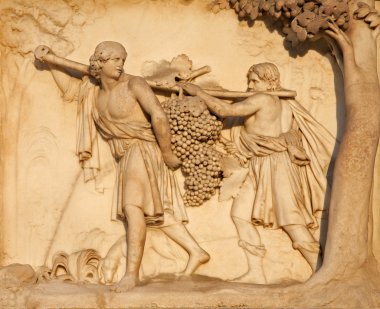 Milan - detail from facade of Duomo - The Spies Return from Canaan Carrying a Large Bunch of Grapes clipart