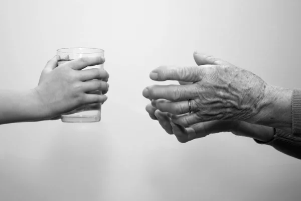 할머니와 손자의 물 유리의 손 — 스톡 사진