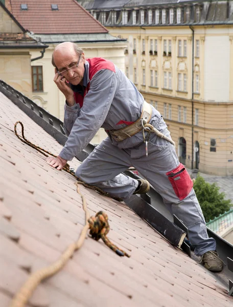 Homem no trabalho e chamando no telhado — Fotografia de Stock