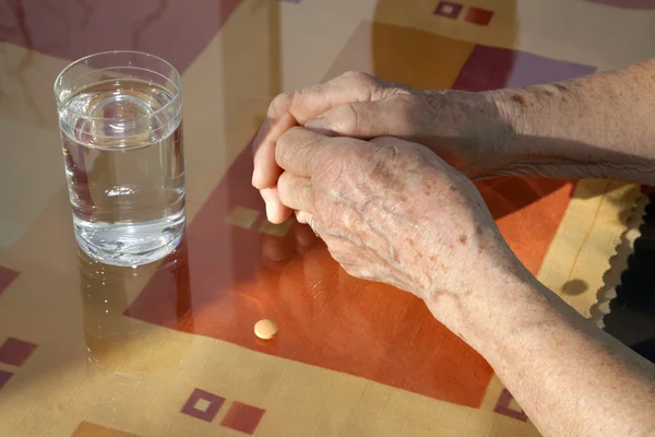 Mani di vecchia e bicchiere d'acqua — Foto Stock