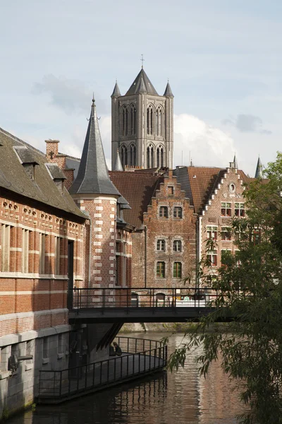 Gent - torn i St nicholas kyrkan och kanalen med de typiska tegelhus. — Stockfoto