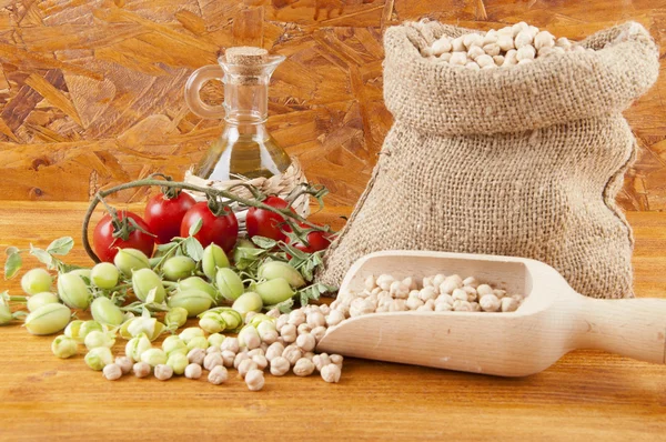 Burlap sack with chickpeas spilling out over a white background