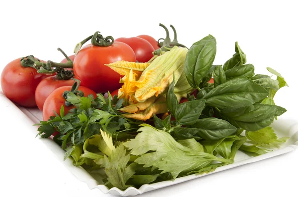 Red tomatoes with squash blossoms and basil — Stock Photo, Image