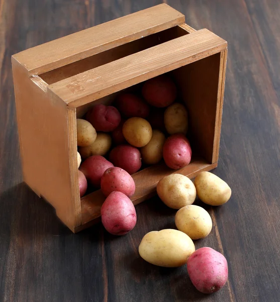Raw potatoes in a wooden box — Stock Photo, Image