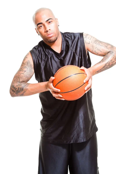 Studio portret van basketbalspeler permanent en houden bal geïsoleerd op wit. tatoeages op zijn armen. — Stockfoto