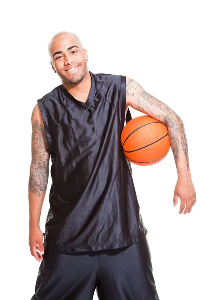 Potret seorang pemain basket muda berdiri dengan bola melawan latar belakang putih. Studio shot. Tato di lengannya . — Stok Foto