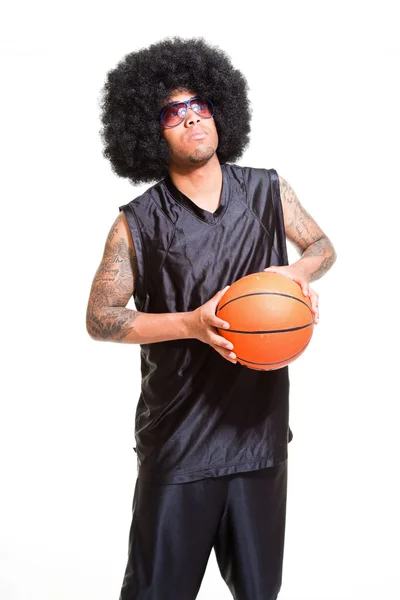 Studioporträt eines Retro-Basketballspielers mit Afro-Haaren stehend und Ball isoliert auf Weiß haltend. Tätowierungen auf seinen Armen. — Stockfoto