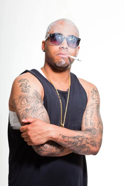 Hiphop urban gangster svart man klädd i mörk tröja och bling bling isolerade på vitt. rökning cigarett. Letar du säker. cool kille. Studio skott. — Stockfoto