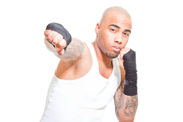 Young male boxer isolated on white background. Wearing white shirt and black shorts. Training outfit. Wet skin from sweating. Tattoos on his arms. — Stock Photo, Image