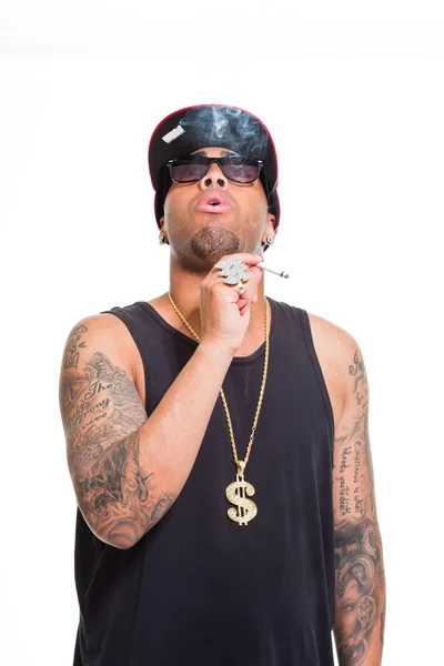 Hip Hop urbaner Gangster schwarzer Mann mit Kappe, dunklem Hemd und Bling Bling vereinzelt auf weißem Hintergrund. Zigarette rauchend. Sieht zuversichtlich aus. Cooler Typ. Studioaufnahme. — Stockfoto