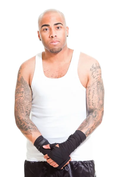 Boxeador masculino joven aislado sobre fondo blanco. Con camisa blanca y pantalones cortos negros. Equipo de entrenamiento. Piel húmeda por sudoración. Tatuajes en sus brazos . —  Fotos de Stock