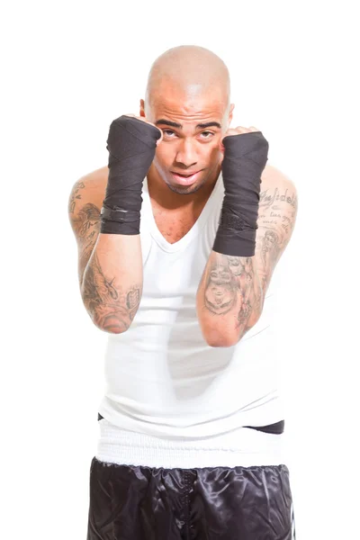 Молодой боксер изолирован на белом фоне. В белой рубашке и черных шортах. Тренировочный костюм. Мокрая кожа от пота. Татуировки на руках . — стоковое фото