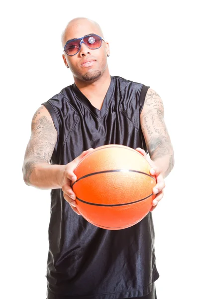 Studio portrait of basketball player wearing black sunglasses standing and holding ball isolated on white. Tattoos on his arms. — Stock Photo, Image