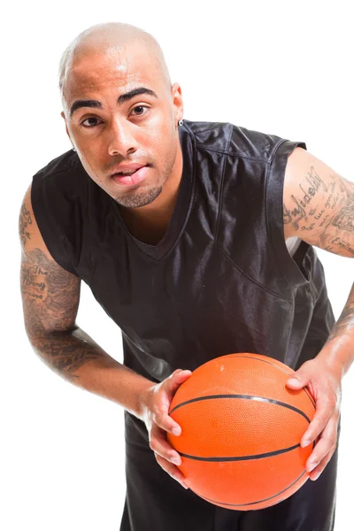 Studio porträtt av basketspelare ständiga och hålla bollen isolerade på vitt. tatueringar på armarna. — Stockfoto