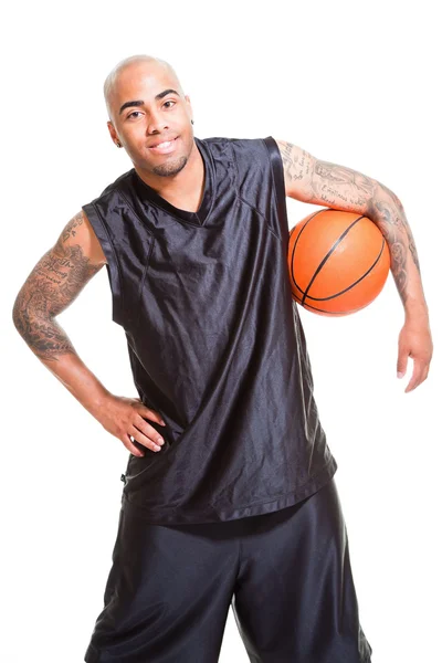 Портрет молодого баскетболіста, що стоїть з м'ячем на білому тлі. Студійний знімок. Татуювання на руках . — стокове фото