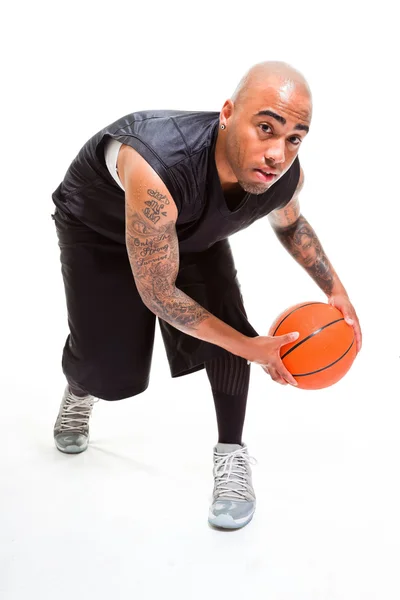 Estúdio retrato de jogador de basquete de pé e segurando bola isolada em branco. Tatuagens em seus braços . — Fotografia de Stock