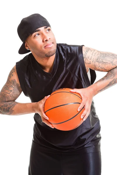 Studio portret van basketbalspeler dragen zwarte pet permanent en houden bal geïsoleerd op wit. — Stockfoto