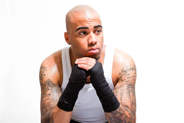 Young male boxer isolated on white background. Wearing white shirt and black shorts. Training outfit. Wet skin from sweating. Tattoos on his arms. — Stock Photo, Image