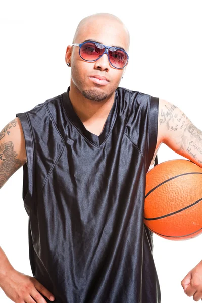 Studio portrét basketbalista černé brýle stojí a drží míč izolovaných na bílém. tetování na ruce. — Stock fotografie