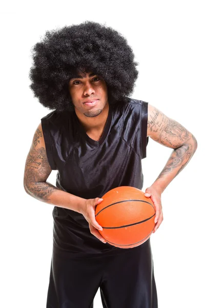 Studio portrait of retro basketball player with afro hair standing and holding ball isolated on white. Tattoos on his arms. — Stock Photo, Image