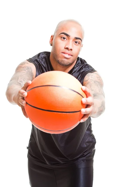 白い背景に対してボールを持って立っている若いバスケット ボール選手の肖像画。スタジオ ショットします。彼の腕に入れ墨. — ストック写真