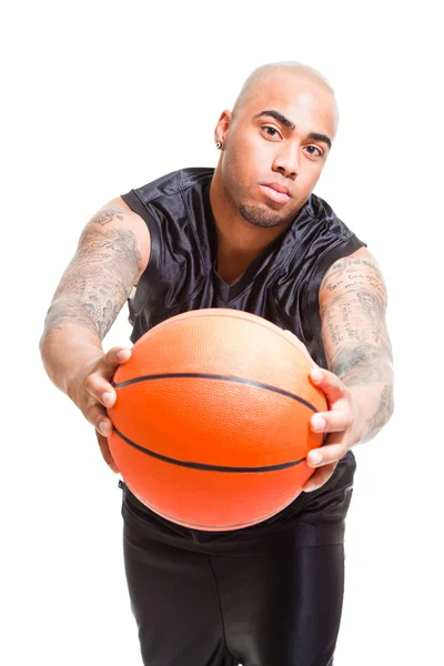 Porträt eines jungen Basketballspielers, der mit einem Ball vor weißem Hintergrund steht. Studioaufnahmen. Tätowierungen auf seinen Armen. — Stockfoto