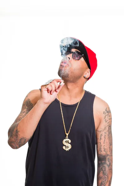 Hip hop urbano gangster hombre negro con gorra, camisa oscura y bling bling aislado en blanco. Fumar cigarrillos. Pareces seguro. Un tipo genial. Captura de estudio . — Foto de Stock