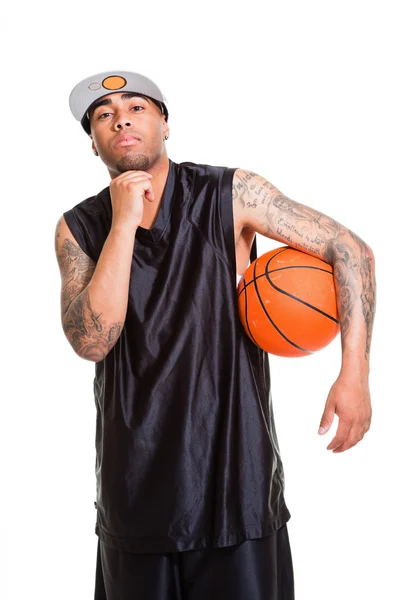 Studio ritratto di giocatore di basket con cappuccio bianco in piedi e tenendo la palla isolata sul bianco. Tatuaggi sulle braccia . — Foto Stock
