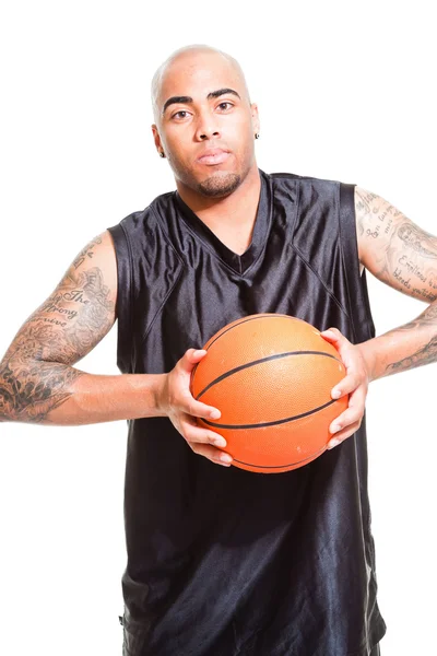 篮球运动员站和持有球上白色隔离室画像。他手臂上的纹身. — 图库照片