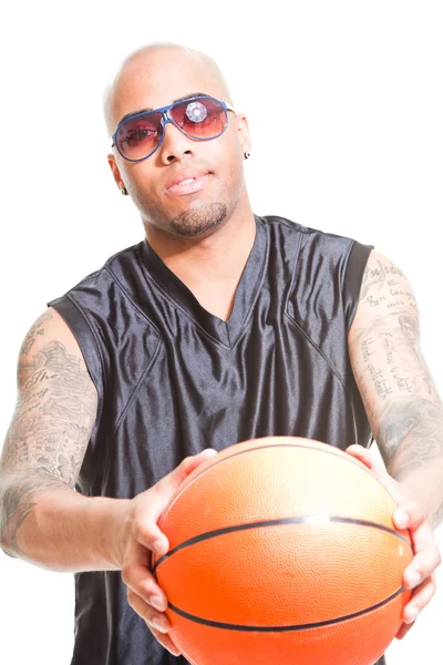 Studio portrait of basketball player wearing black sunglasses standing and holding ball isolated on white. Tattoos on his arms. — Stock Photo, Image
