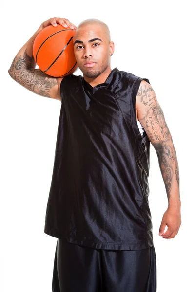 白い背景に対してボールを持って立っている若いバスケット ボール選手の肖像画。スタジオ ショットします。彼の腕に入れ墨. — ストック写真
