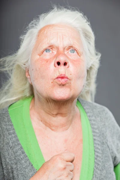 Äldre kvinna vit grått hår gör andliga poser. uttrycksfullt ansikte och händer. Studio skott isolerade på grå bakgrund. — Stockfoto