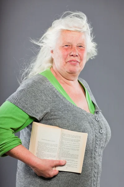 Retrato de estúdio de mulher idosa lendo um livro. Estúdio tiro isolado em fundo cinza . — Fotografia de Stock