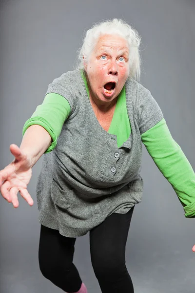 Drôle de femme âgée expressive. Agir jeune. Studio tourné isolé sur fond gris . — Photo