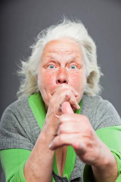 Mujer mayor de pelo gris blanco con expresiva cara emocional y manos. Estudio plano aislado sobre fondo gris . — Foto de Stock