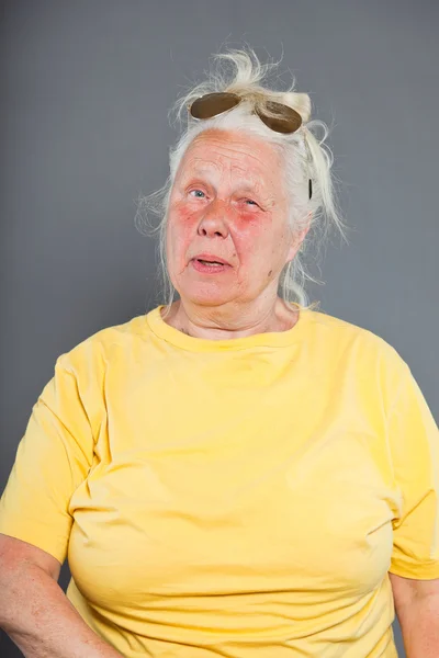 サングラスと灰色の長い髪を持つクールなヒップ年配の女性。表情豊かな顔。スタジオ撮影に分離グレー. — ストック写真
