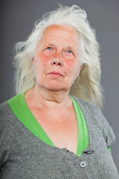 Старша жінка біло-сіре волосся робить духовні пози. Виразне обличчя і руки. Студійний знімок ізольовано на сірому фоні . — стокове фото