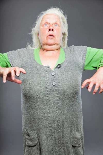 Donna anziana capelli bianchi grigi facendo pose spirituali. Viso e mani espressivi. Studio girato isolato su sfondo grigio . — Foto Stock